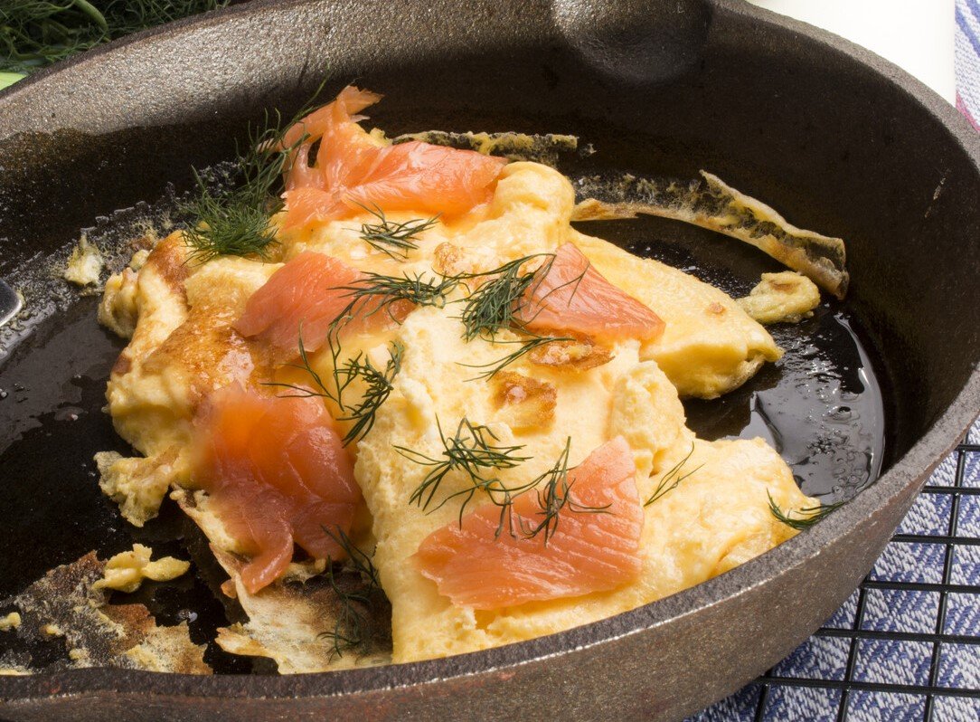 omelette per cani, con salmone e aneto, in una padella nera
