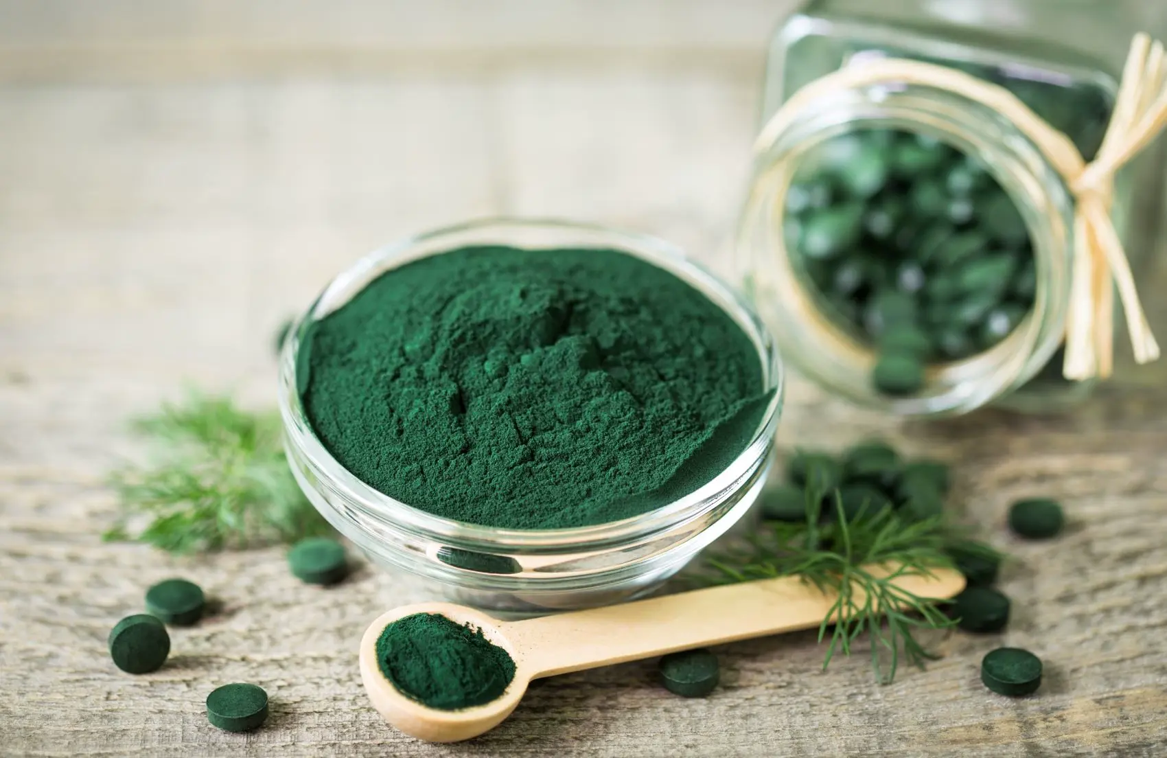 spirulina in polvere e in compresse su tavolo in legno