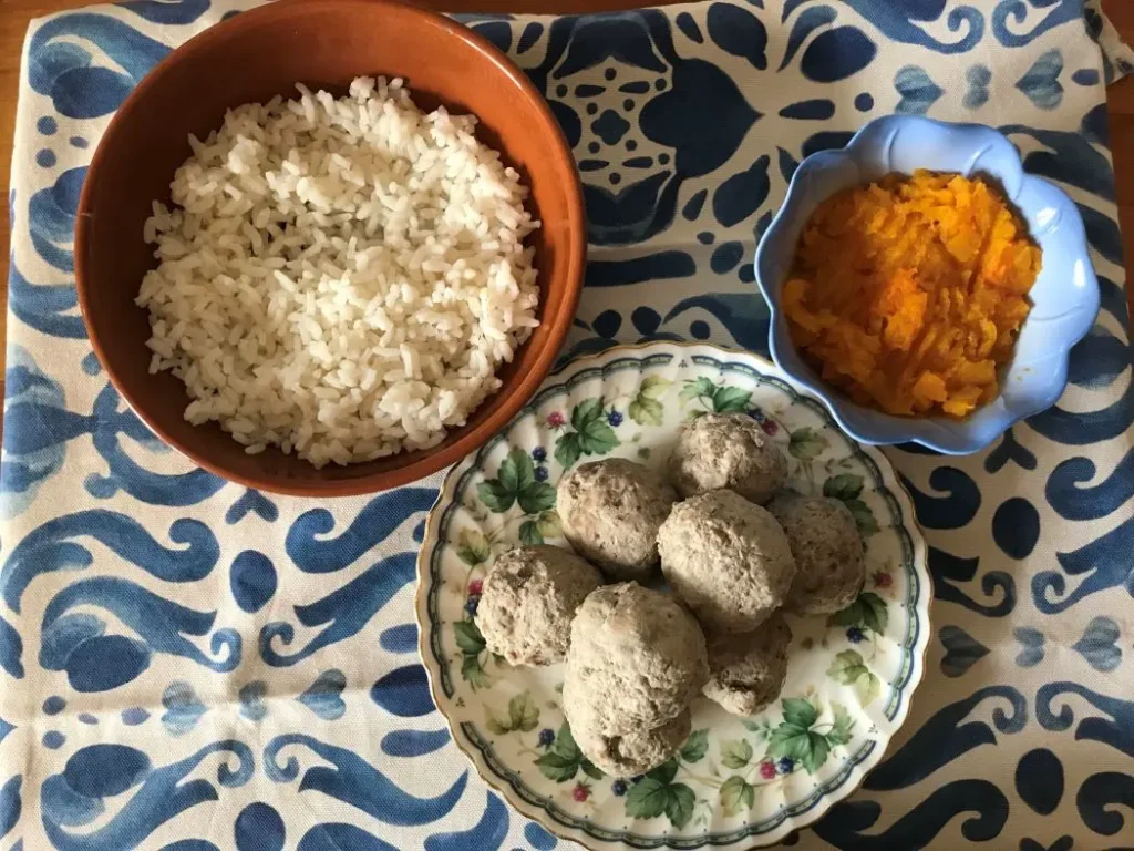 su una tovaglia bianca e azzurra citole conteneti pure di zucca, canederli di tacchino e riso